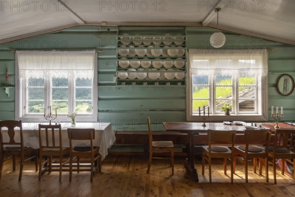 Esszimmer mit Holztischen, Holzstühlen und Tellern in einem Regal, historischer Bauernhof und Pilgerunterkunft Budsjord, Dovre, Pilgerweg Olavsweg oder Olavsleden, Gudbrandsdalen oder Gudbrandstal, Norwegen