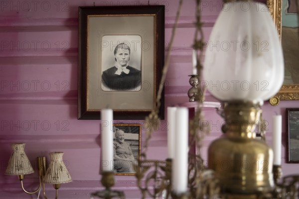 Alte Schwarzweiß-Fotografien an rosa gestrichener Wand, nostalgische Atmosphäre, historischer Bauernhof und Pilgerunterkunft Budsjord, Dovre, Pilgerweg Olavsweg oder Olavsleden, Gudbrandsdalen oder Gudbrandstal, Norwegen