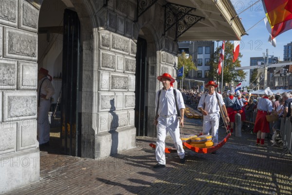 Männer mit Käse laufen durch ein historisches Marktgelände mit Publikum, ehemalige Stadtwaage, Käseträger, Käse, Käsemarkt, Alkmaar, Alkmar, Noord-Holland, Nordholland, Niederlande