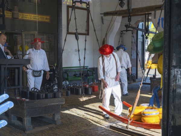 Männer in traditioneller Kleidung transportieren Käse in einem geschlossenen Raum, ehemalige Stadtwaage, Käse wiegen, Käseträger, Käse, Käsemarkt, Alkmaar, Alkmar, Noord-Holland, Nordholland, Niederlande