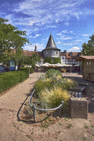 Fachwerkhäuser, Turm, Blumenbeet, Parkplatz mit Auto, Bäume, Hecke, Restaurant Zum Türmchen, Außenbereich einer Gastronomie mit Sonnenschirmen, blauer Himmel, Cumuluswolken, Cirrostratuswolken, Platz am Untertor, Burggrabenstraße, Hofheim am Taunus, Main-Taunus-Kreis, Hessen, Deutschland