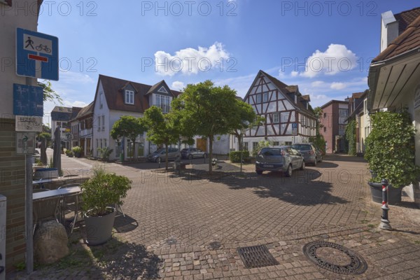 Platz, Fachwerkhaus, allgemeine Architektur, Gebäude, Straßen, Parkstreifen mit Autos, Absperrpoller, Außenbereich einer Gastronomie mit Tischen und Stühlen, Bäume, Gegenlicht, blauer Himmel, Cumuluswolken, Kreuzung Bornplatz mit Kurhausstraße und Krebsgasse, Hofheim am Taunus, Main-Taunus-Kreis, Hessen, Deutschland