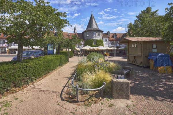 Fachwerkhäuser, Turm, Blumenbeet, Parkplatz mit Auto, Bäume, Hecke, Restaurant Zum Türmchen, Außenbereich einer Gastronomie mit Sonnenschirmen, blauer Himmel, Cumuluswolken, Cirrostratuswolken, Platz am Untertor, Burggrabenstraße, Hofheim am Taunus, Main-Taunus-Kreis, Hessen, Deutschland