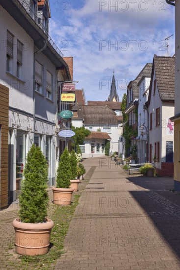 Fußgängerzone, Gebäude, allgemeine Architektur, Einzelhandelsgeschäfte, Zigarrenhaus Knöss, House of Smoke, Schuhmode Benner, Nasenschilder, einkaufen, Lottogeschäft, Schuhgeschäft, Tabakgeschäft, Blumenkübel, Kirchturm der Evangelischen Johanneskirche, blauer Himmel, Cumuluswolken, Kurhausstraße, Hofheim am Taunus, Main-Taunus-Kreis, Hessen, Deutschland