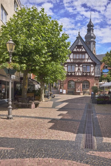 Historisches Rathaus, Altes Rathaus Café Hofheim am Taunus, Fachwerkhaus, allgemeine Architektur, Fußgängerzone, Gehweg aus Pflastersteinen, Mosaik, Kirchturm der Pfarrkirche St. Peter und Paul, Bäume, blauer Himmel, Altocumuluswolken, Cumuluswolken, Kreuzung Langgasse mit Hauptstraße, Hofheim am Taunus, Main-Taunus-Kreis, Hessen, Deutschland