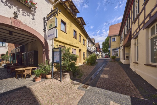 Fußgängerzone, allgemeine Architektur, Wohngebäude und Geschäftsgebäude, Fachwerkhaus, Restaurant Ristorante L'Opera, Akustiker, Nasenschild, Gehweg aus Pflastersteinen, blauer Himmel, Cumuluswolken, Langgasse, Hofheim am Taunus, Main-Taunus-Kreis, Hessen, Deutschland