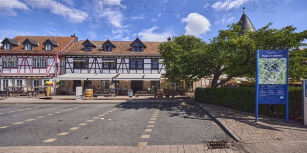 Platz am Untertor, Fachwerkhäuser, Häuserzeile, historische Gebäude, Gauben, Eisdiele, Außenbereich einer Gastronomie, Parkplatz, Standorttafel, Bäume, Hecke, blauer Himmel, Cumuluswolken, Burggrabenstraße, Hofheim am Taunus, Main-Taunus-Kreis, Hessen, Deutschland