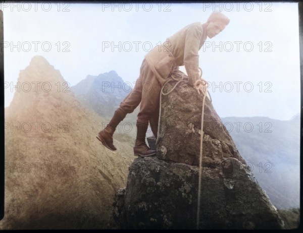 Colourised image of male rock climber thought to be Cuillin mountains, Skye, Scotland, UK c 1900-1920
