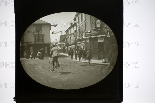 People gathering for a patriotic event with bunting flags across the street, possibly Edinburgh, Scotland, end of Boer War 1902