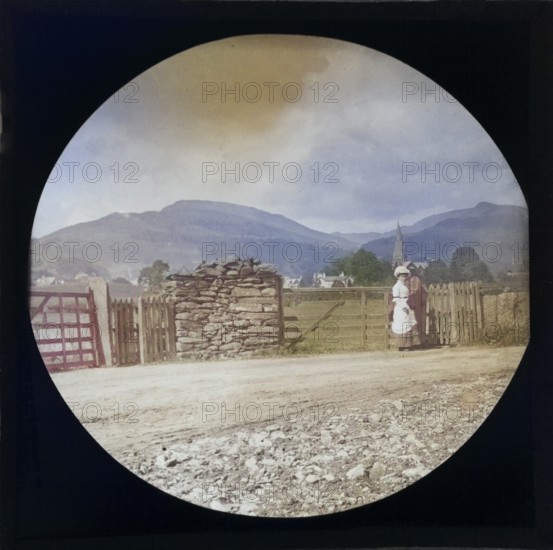 Woman Victorian or Edwardian tourist with background of Ambleside, Lake District, Cumbria, England, UK c 1900