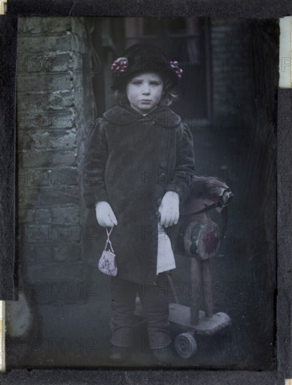 Paget process colourised magic lantern slide portrait of a young girl dressed up in adult clothing, circa 1900