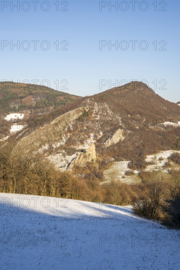 Cervenokamenské cliff (cervenokamenske bradlo), a huge rock at a mountain with bushes, trees and meadows in winter, Vápec, Horná Poruba, Slovakia