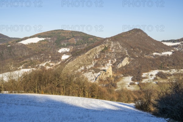 Cervenokamenské cliff (cervenokamenske bradlo), a huge rock at a mountain with bushes, trees and meadows in winter, Vápec, Horná Poruba, Slovakia