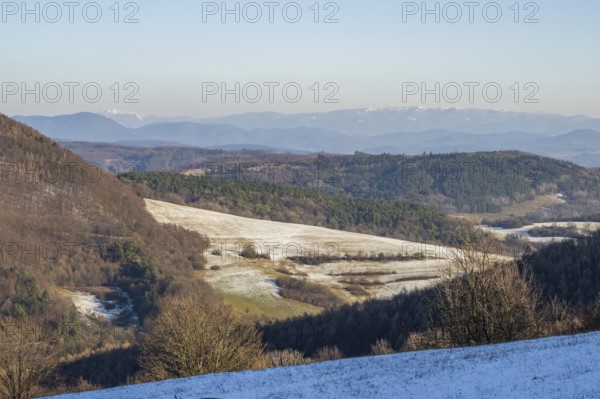 Typical valley with bushes, trees and meadows with the high tarta mountains in the background in winter, Vápec, Horná Poruba, Slovakia