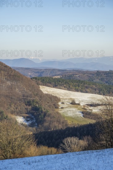 Typical valley with bushes, trees and meadows with the high tarta mountains in the background in winter, Vápec, Horná Poruba, Slovakia