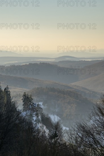 View over the hills and valleys from the mountain with hoarfrost on the branches in winter, Vápec, Horná Poruba, Slovakia