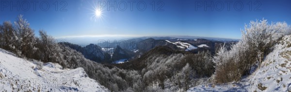 View over the hills and valleys from the mountain with hoarfrost on the branches in winter, Vápec, Horná Poruba, Slovakia