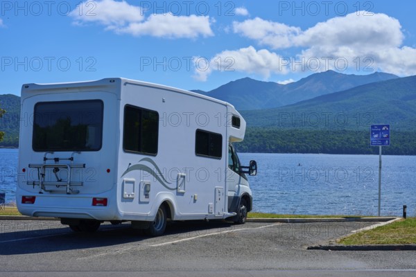 Motorhome in a car park overlooking a tranquil lake and mountains, Te Anau, Lake Te Anau, Southland District, South Island, New Zealand