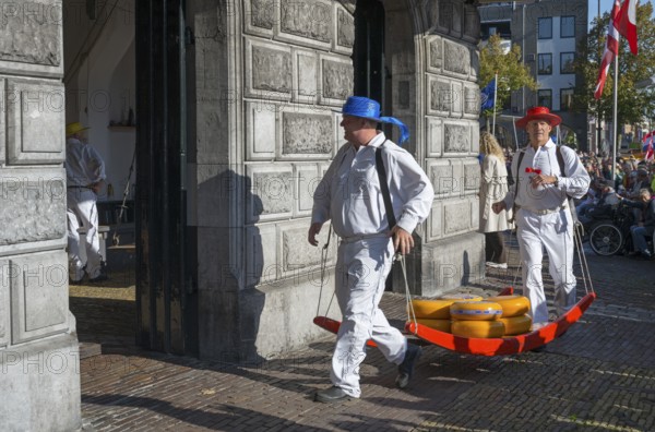 Men in traditional clothing transporting cheese at a historic building, cheese carrier, cheese, cheese market, former city scales, Alkmaar, Alkmar, Noord-Holland, North Holland, Netherlands