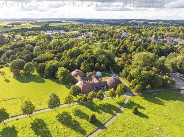 Extensive green landscape with shade, surrounded by a variety of trees and a central building, Bad Dürrheim, Germany