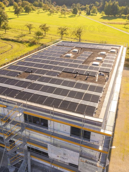 Close-up of a building with solar panels and scaffolding in green surroundings, new building with green roof and PV system, Wiernsheim, Germany