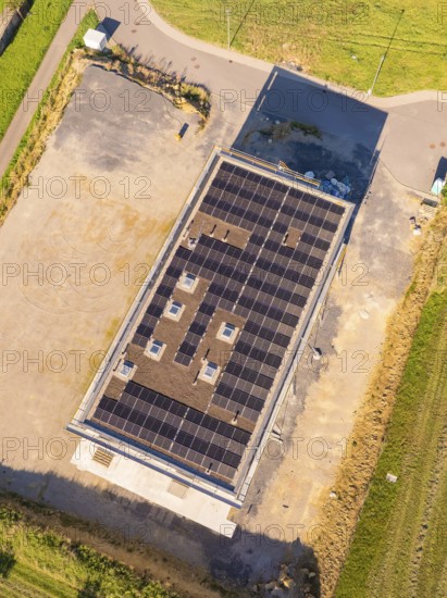 Top view of building with solar roof surrounded by an open area and fields, new building with green roof and PV system, Wiernsheim, Germany
