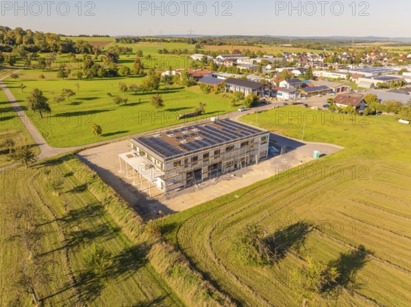 New building with solar panels, embedded in green fields, near a village, new building with green roof and PV system, Wiernsheim, Germany