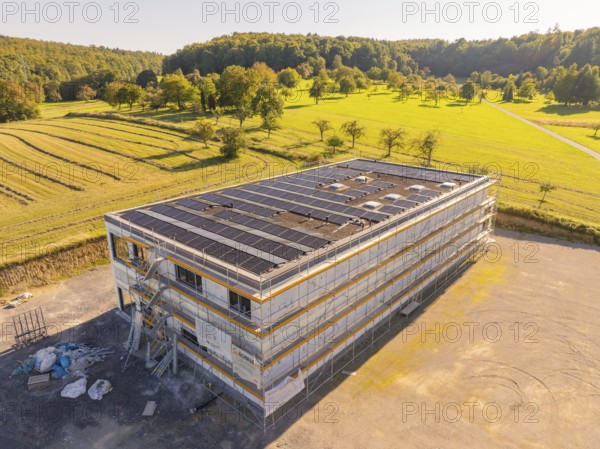 Modern building with solar panels surrounded by fields and forests, under construction, new build with green roof and PV system, Wiernsheim, Germany