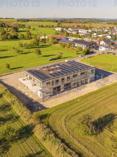 New building with solar panels on the roof, embedded in a green landscape near a village, new building with green roof and PV system, Wiernsheim, Germany