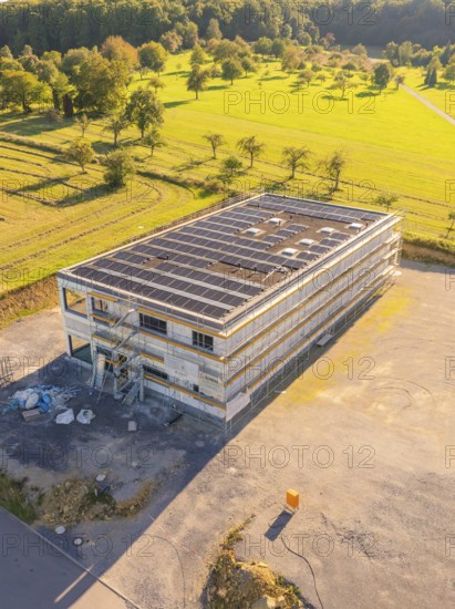 Building with solar panels and scaffolding in a landscaped setting, new build with green roof and PV system, Wiernsheim, Germany