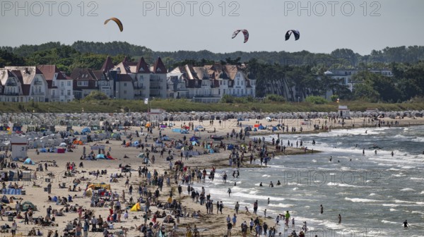 Kitesurfers float along a lively beach, surf, Warnemünde, Rostock, Mecklenburg-Vorpommern, Germany