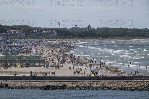 Kitesurfer over lively beach, surf, Warnemünde, Rostock, Mecklenburg-Vorpommern, Germany