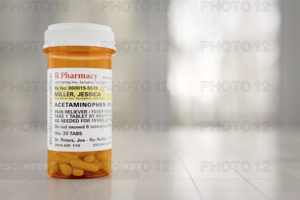 Acetaminophen prescription medicine bottle resting on A bathroom countertop. the label is non-proprietary, fictional, made specifically for the stock photo industry