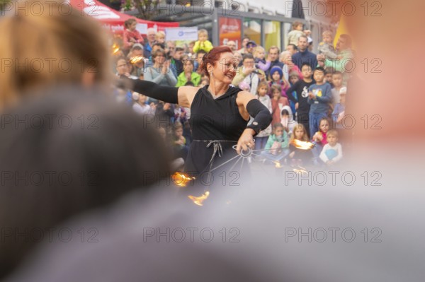 Energetic demonstration with fire wheels in front of an excited audience and curious children, Feuernacht, Sindelfingen, Germany