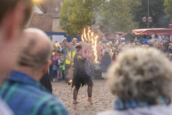 Dancer with burning torch, surrounded by an attentive audience at a street festival, Fire Night, Sindelfingen, Germany