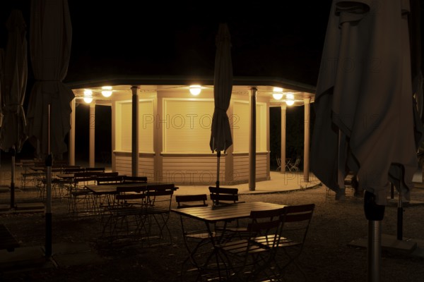 Night shot of a closed kiosk with seating and folded sunshades in the Herrenhausen Gardens, Herrenhausen, Hanover, Lower Saxony, Germany
