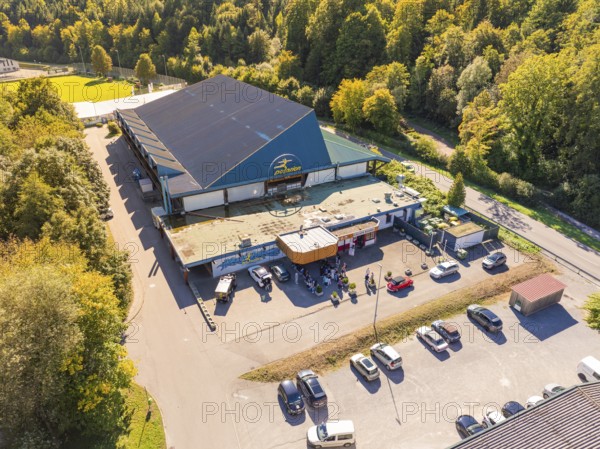 Building with large car park, surrounded by forest and green areas, sunny atmosphere, Polarion Ice Stadium, Bad Liebenzell, Black Forest, Germany