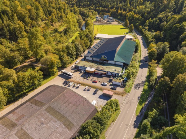 Industrial building complex near a road in the countryside, large car park, sunny atmosphere, Polarion ice stadium, Bad Liebenzell, Black Forest, Germany