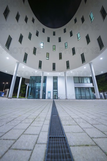 Illuminated entrance area of a modern building with columns, Munich, Germany