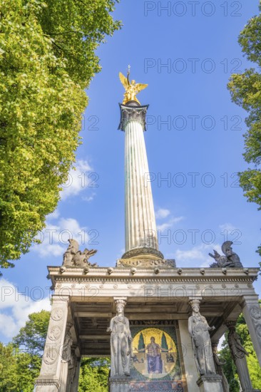 A victory column with a golden figure and detailed reliefs, Munich, Germany