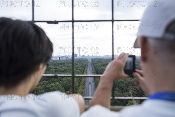 Two people photographing the start of the 51st BMW Berlin Marathon 2025 on 21 September 2025 from the Victory Column on Straße des 17
