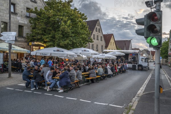 Residents celebrating Kirchweih in front of an inn on the closed B2, Eschenau, Middle Franconia, Bavaria, Germany