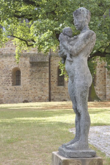 Sculpture Mother and Child by Sabine Grzimek 1981, bronze sculpture, life-size, modern art, standing female figure carrying infant in her arms, infant, protect, relationship, care, sculpture park, Magdeburg, Saxony-Anhalt, Germany