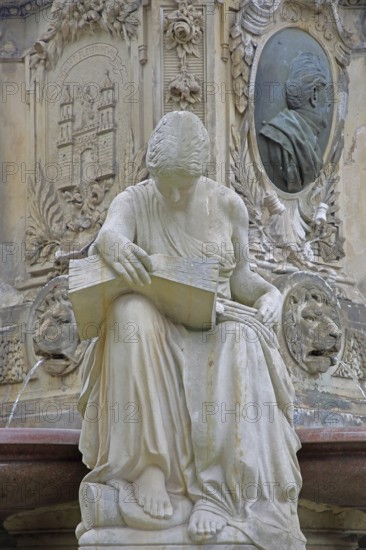 Seated white female figure reading a thick book as a symbol of science, allegory, knowledge, reading, city coat of arms, relief and monument to Lord Mayor Gustav Hasselbach, book reader, Hasselbach Fountain, Haydnplatz, Magdeburg