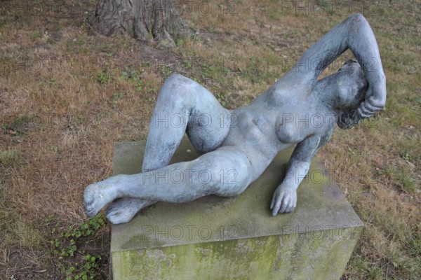 Sculpture Lying woman by Heinrich Drake 1930, nude female figure, one arm over head, bronze sculpture, life-size, Sculpture Park, Magdeburg, Saxony-Anhalt, Germany