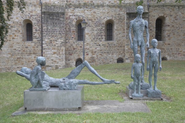 Sculpture Standing and Resting Group by Sabine Grzimek 1985, reclining and standing nude slender male figures, children, boy, girl, bronze sculptures, life-size, modern art, sculpture group, sculpture park, Magdeburg, Saxony-Anhalt, Germany