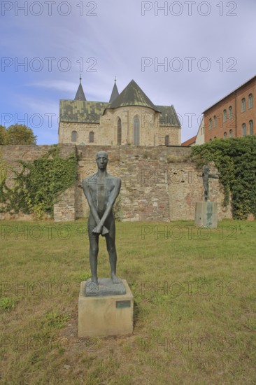 Sculpture Freedom Fighter by Fritz Cremer 1947, sculpture park, standing male figure with arms crossed, crossed over each other, crosswise, bronze sculpture, life-size, Romanesque, church, Monastery of Our Lady, art museum, sculpture park, Magdeburg, Saxony-Anhalt, Germany