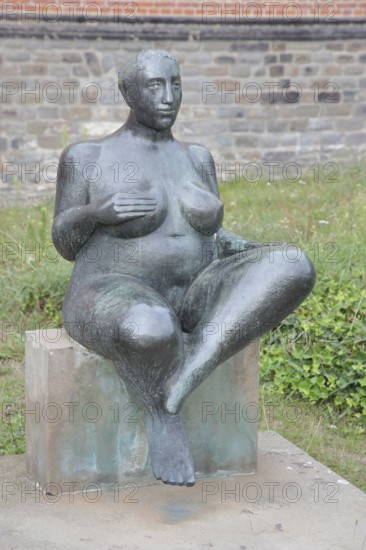 Sculpture Sitting woman - Expectation by Peter Kern 1984, bronze sculpture, squatting plump nude female figure, plump, one hand on breast, Sculpture Park, Magdeburg, Saxony-Anhalt, Germany