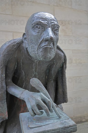 Albertus Magnus by Heinrich Apel 1985, medieval scholar and bishop writing with quill, bronze sculpture, monument, face, head, nose, look, look, see, frontal, perspective, Magnus monument, St. Petri, Magdeburg, Saxony-Anhalt, Germany