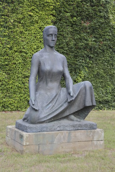 Sculpture Mother Earth by Fritz Cremer 1951, seated female figure, bronze sculpture, life-size, arms, gesture, symbol, religious, philosophical, nature, sculpture park, Magdeburg, Saxony-Anhalt, Germany